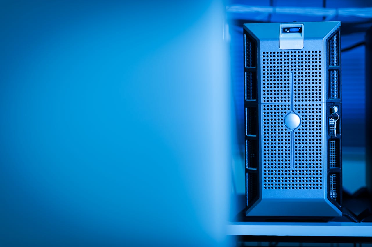 about-img-01 Close-up of a modern server unit in a blue-lit data center environment.